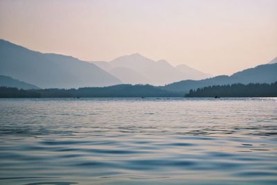 Scenic view of lake and mountains against sky during sunset