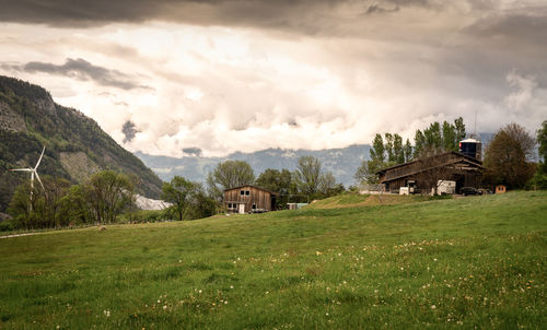 Scenic view of field and houses against sky