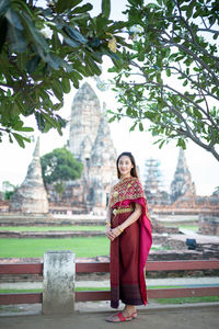 Portrait of young woman standing against temple