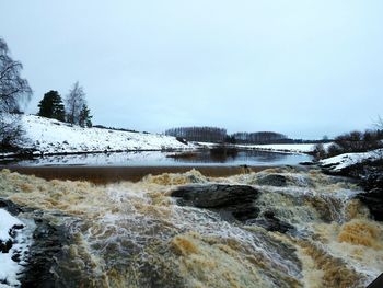 Scenic view of river against sky during winter