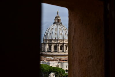 Historic building against sky seen through arch