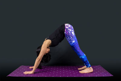 Midsection of person wearing mask against black background