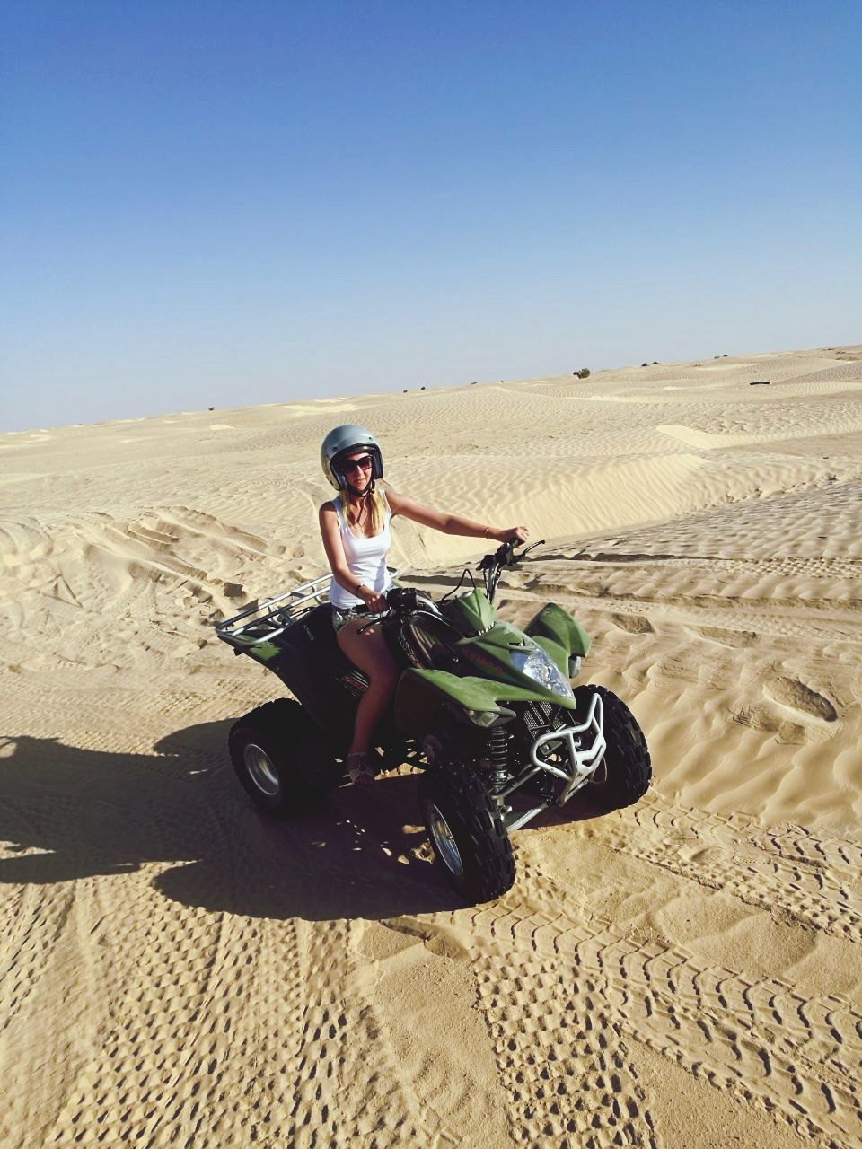 YOUNG WOMAN RIDING MOTORCYCLE IN DESERT