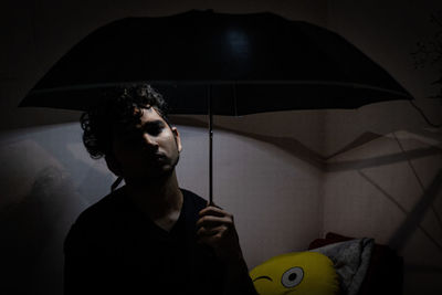 Portrait of young man standing on wet glass
