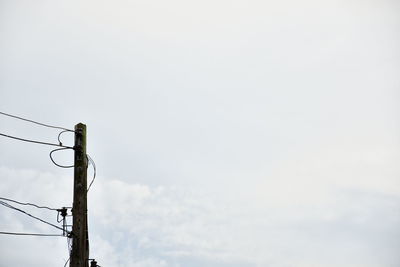 Low angle view of electricity pylon against sky