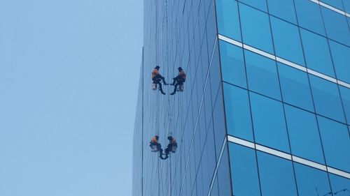 Low angle view of people against clear sky