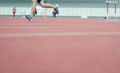 Low section of man running on track