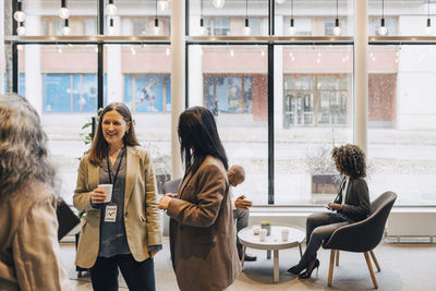 Businesswomen discussing with each other during networking event at convention center