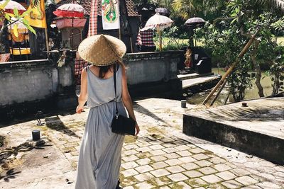 Rear view of woman standing by hat