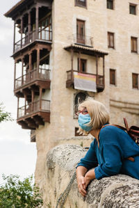Woman sitting outside building
