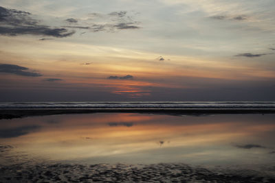 Scenic view of beach against sky during sunset