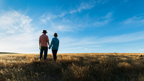 Tourists standing on the dry yellow grass and enjoying the autumn at lake tekapo