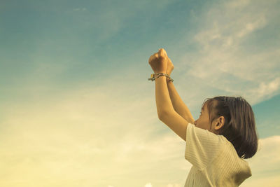 Girl handcuffs against cloudy sky