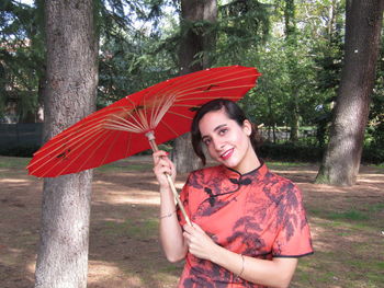 Portrait of smiling young woman standing in rain