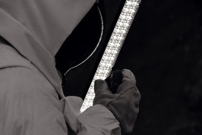 Cropped image of man holding lightning equipment 