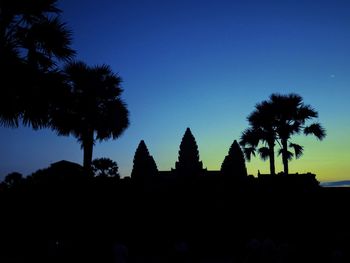 Low angle view of silhouette palm trees against clear sky