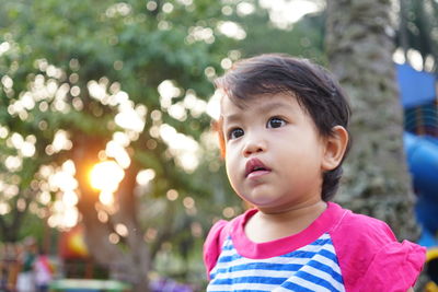 Portrait of cute boy looking away outdoors