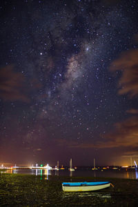 Boats moored on sea against sky at night