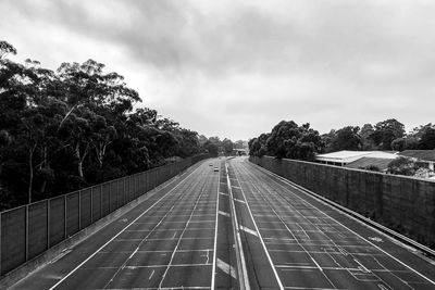 Road amidst trees against sky