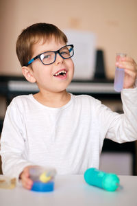 Boy is engaged in scientific research. a child with a test tube and a pipette in his hands. 