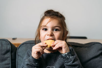 Portrait of cute girl eating food at home