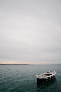 Boat moored in sea against sky