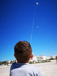 Rear view of a boy against sky