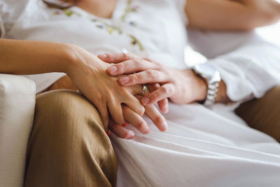 Midsection of couple holding hands