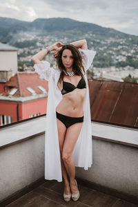 Portrait of woman wearing lingerie while standing on terrace