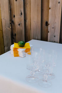 Close-up of lemon on napkins by drinking glasses at table