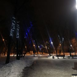 Panoramic view of illuminated street during winter at night