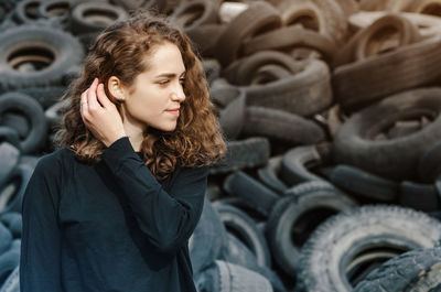 Young woman standing by tires