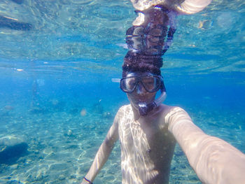 Portrait of shirtless man swimming in sea