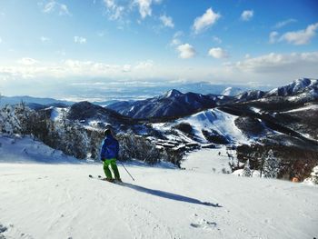 Man on snowcapped mountains against sky