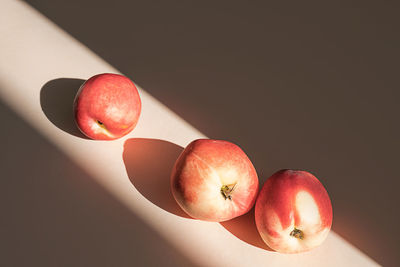 Peaches in sunlight. minimalism, trendy still life with shadow.