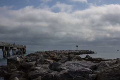 Scenic view of groyne in sea against sky