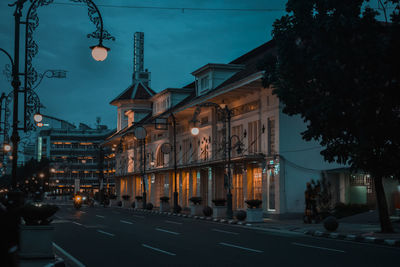 Street amidst buildings in city at night