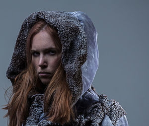 Portrait of serious young woman wearing animal skin clothing