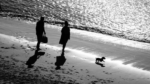 Silhouette of couple standing on beach 