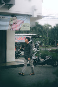 Full length of man standing on street in city