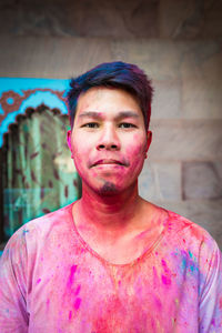 Portrait of young man covered with powder paint during holi