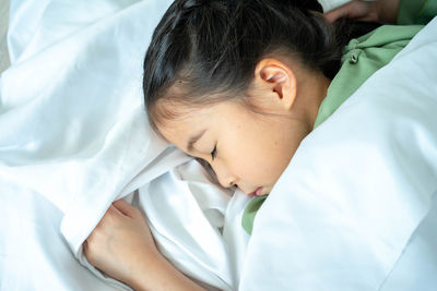 High angle view of baby sleeping on bed