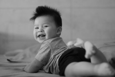 Portrait of cute baby lying on bed at home