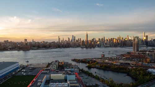 High angle view of river by buildings against sky during sunset