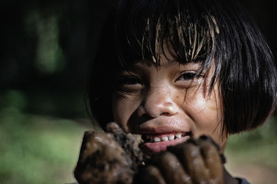 Close-up portrait of girl covered in mud
