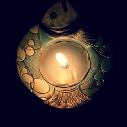 Close-up of illuminated lamp over black background