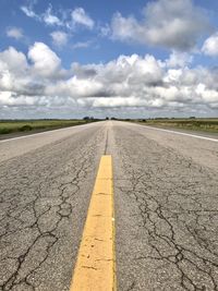 Surface level of road against cloudy sky
