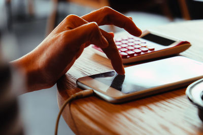 Close-up of person using mobile phone on table