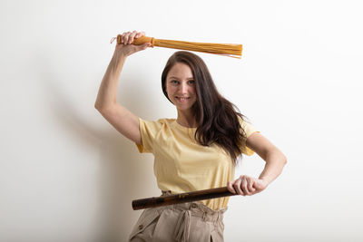 Portrait of smiling woman standing against white background