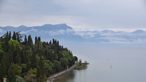 Scenic view of sea and mountains against sky